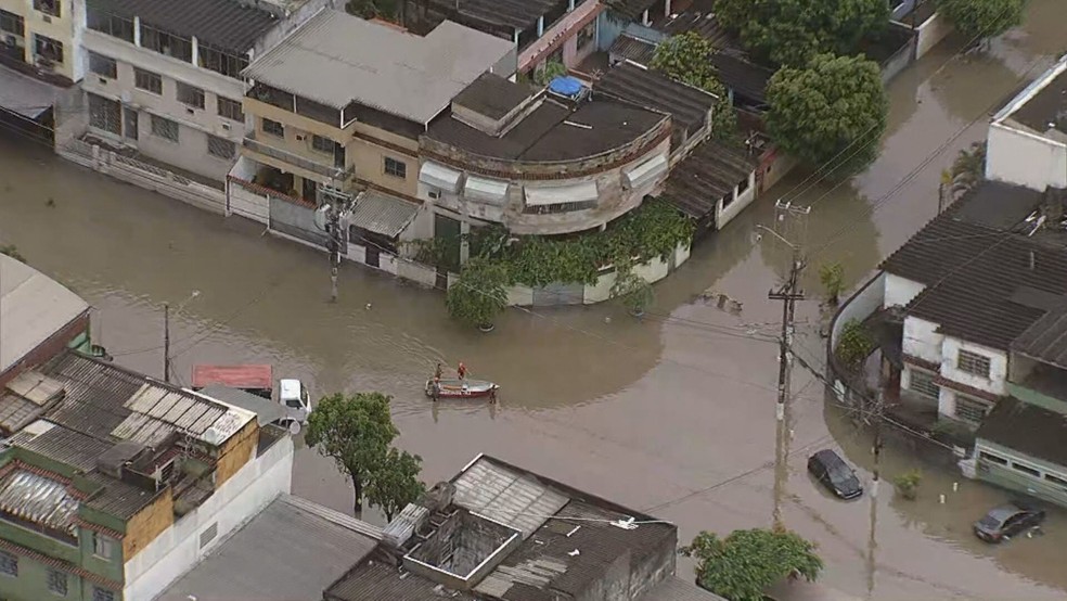 Rua alagada com pessoas usando bote no Jardim América, Zona Norte do Rio, após fortes chuvas — Foto: Amadeu Queiroz/TV Globo