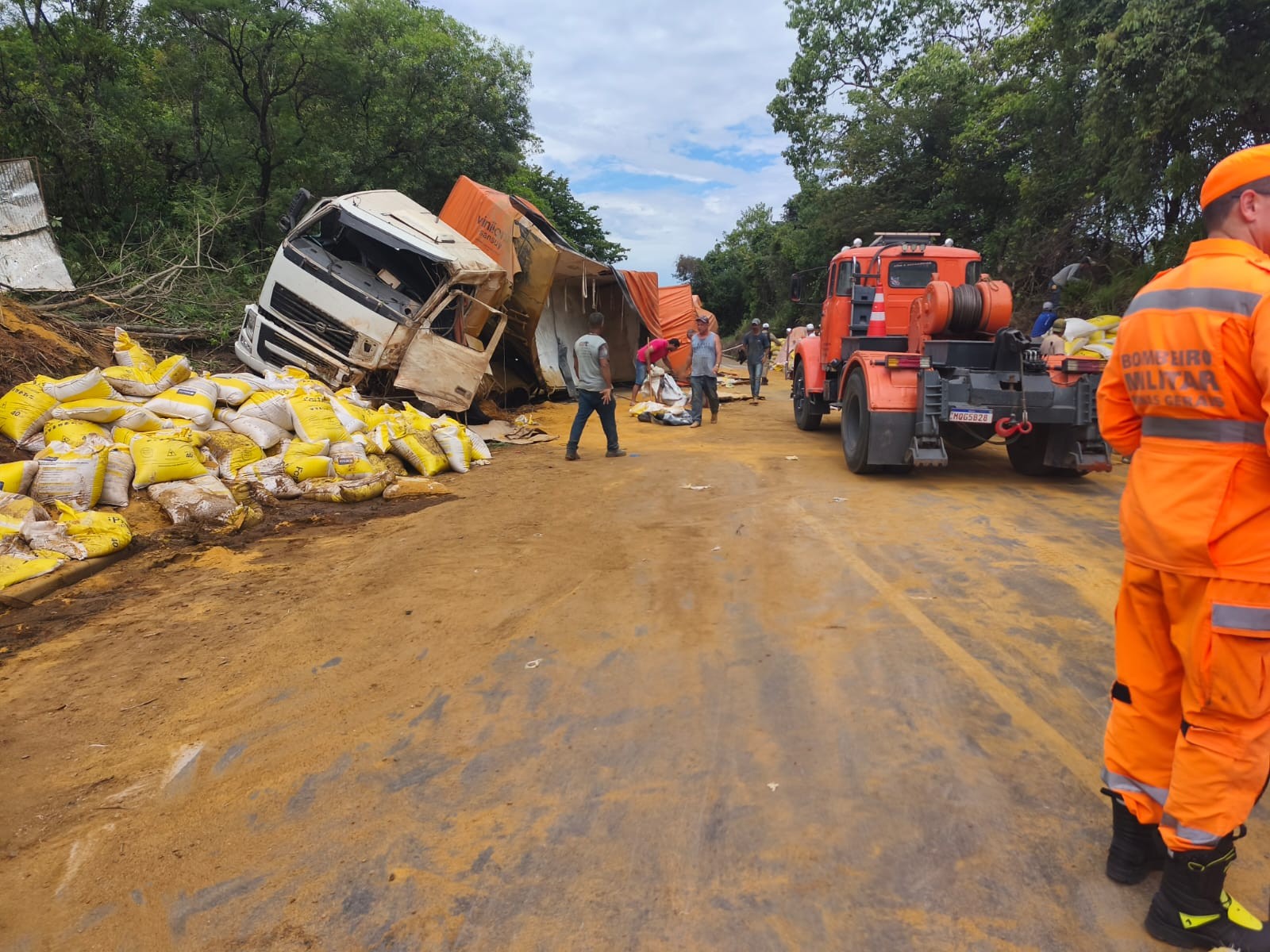 Carreta com 38 toneladas de farelo de milho capota e motorista fica gravemente ferido na BR-354, em MG