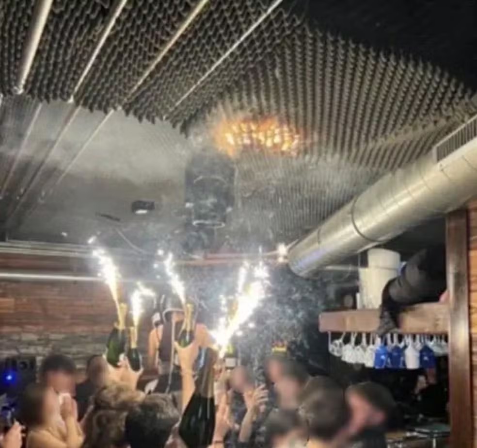 Imagem mostra teto de bar em estação de esqui da Suíça que pegou fogo já em chamas enquanto frequentadores levantam bebidas com sinalizadores, em 1º de dezembro de 2025 — Foto: Reprodução/ Redes Sociais