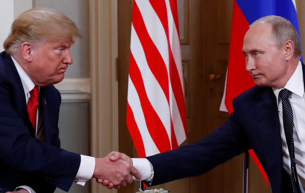 Presidentes Donald Trump e Vladimir Putin se cumprimentam no início de encontro em Helsinque, na Finlândia, em 2018 — Foto: Kevin Lamarque/ Reuters