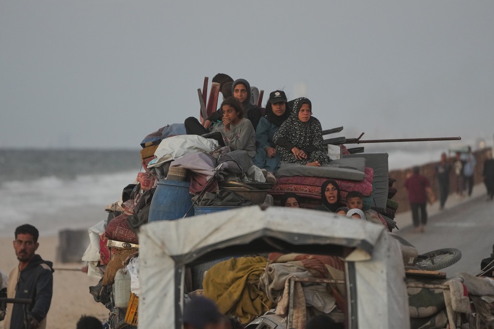 Família palestina viaja em um caminhão carregado de pertences no rumo da Cidade de Gaza, em 10 de outubro de 2025 — Foto: AP Photo/Abdel Kareem Hana