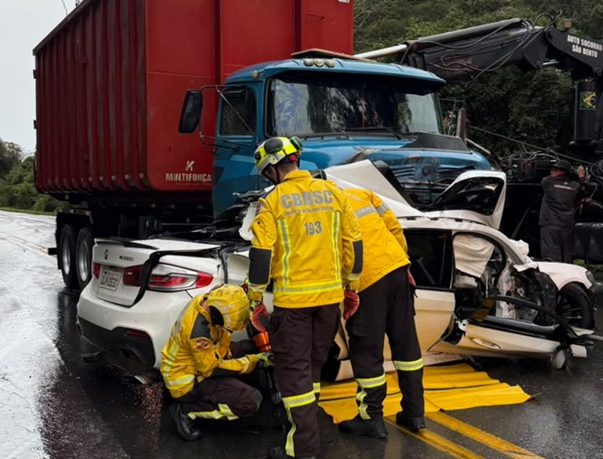 Mulher de 26 anos morre após carro de luxo rodar na pista e parar embaixo de caminhão na SC-418