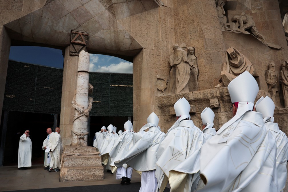 Clérigos vestidos de batinas brancas entram na Basílica da Sagrada Família antes da missa do papa Leão XIV em 10 de junho de 2026. — Foto: REUTERS/Yara Nardi
