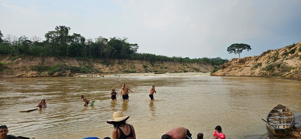 Acreanos se refrescam em 'cachoeira' que se formou em Porto Acre — Foto: Tácita Muniz/g1