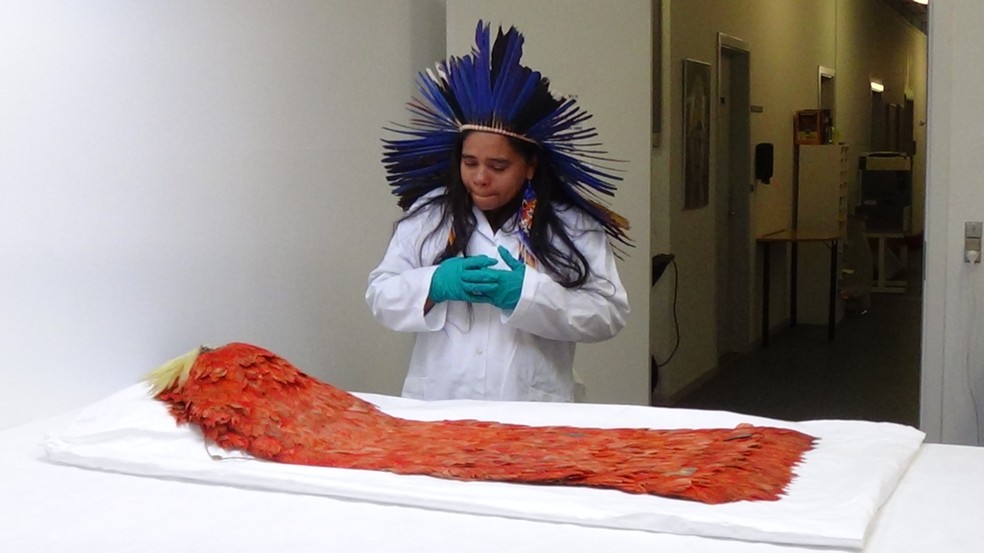 Gliceria Tupinambá em encontro com o manto de seus ancestrais no Museu Nacional da Dinamarca, em Copenhague, em 2022.  — Foto: Renata Cursio Valente/Setor de Etnografia e Etnologia do Departamento de Antropologia do Museu Nacional (URFJ)
