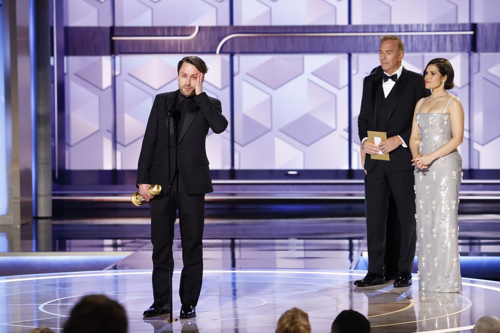 Kieran Culkin agradece pelo prêmio por sua atuação em 'Succession' no Globo de Ouro 2024 com os apresentadores Kevin Costner e America Ferrera — Foto: Sonja Flemming/CBS via AP