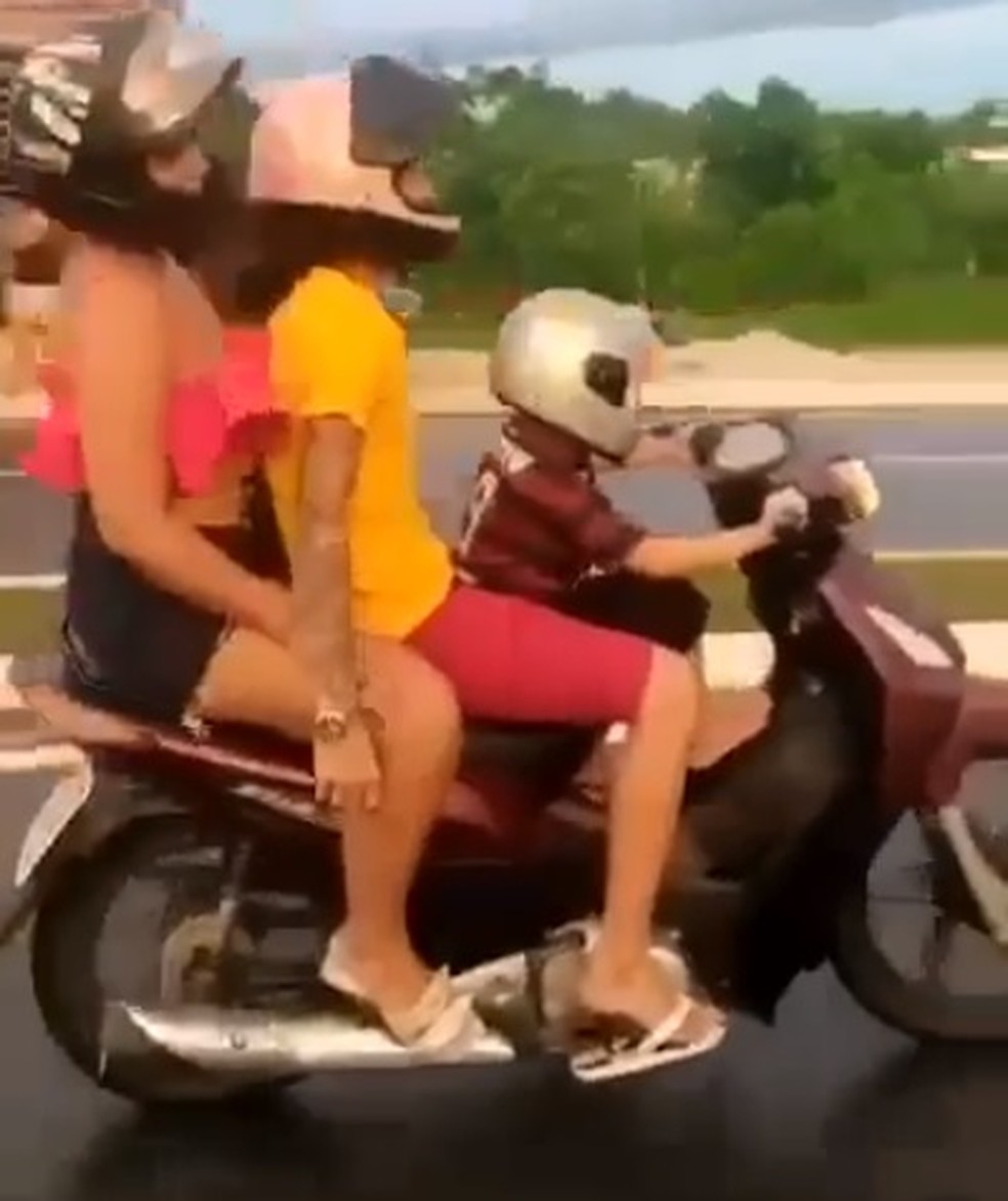 Criança Andando De Moto Com a Mão Levantada Imagem de Stock