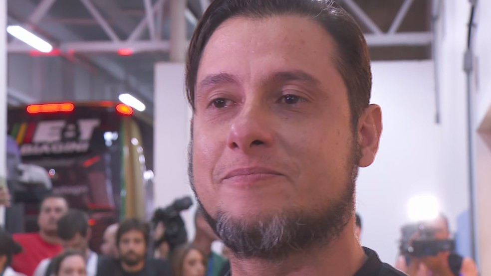 Deportado, o corretor de imóveis César Diego Justino beijou o chão do aeroporto ao chegar em Confins. — Foto: Henrique Campos/TV Globo