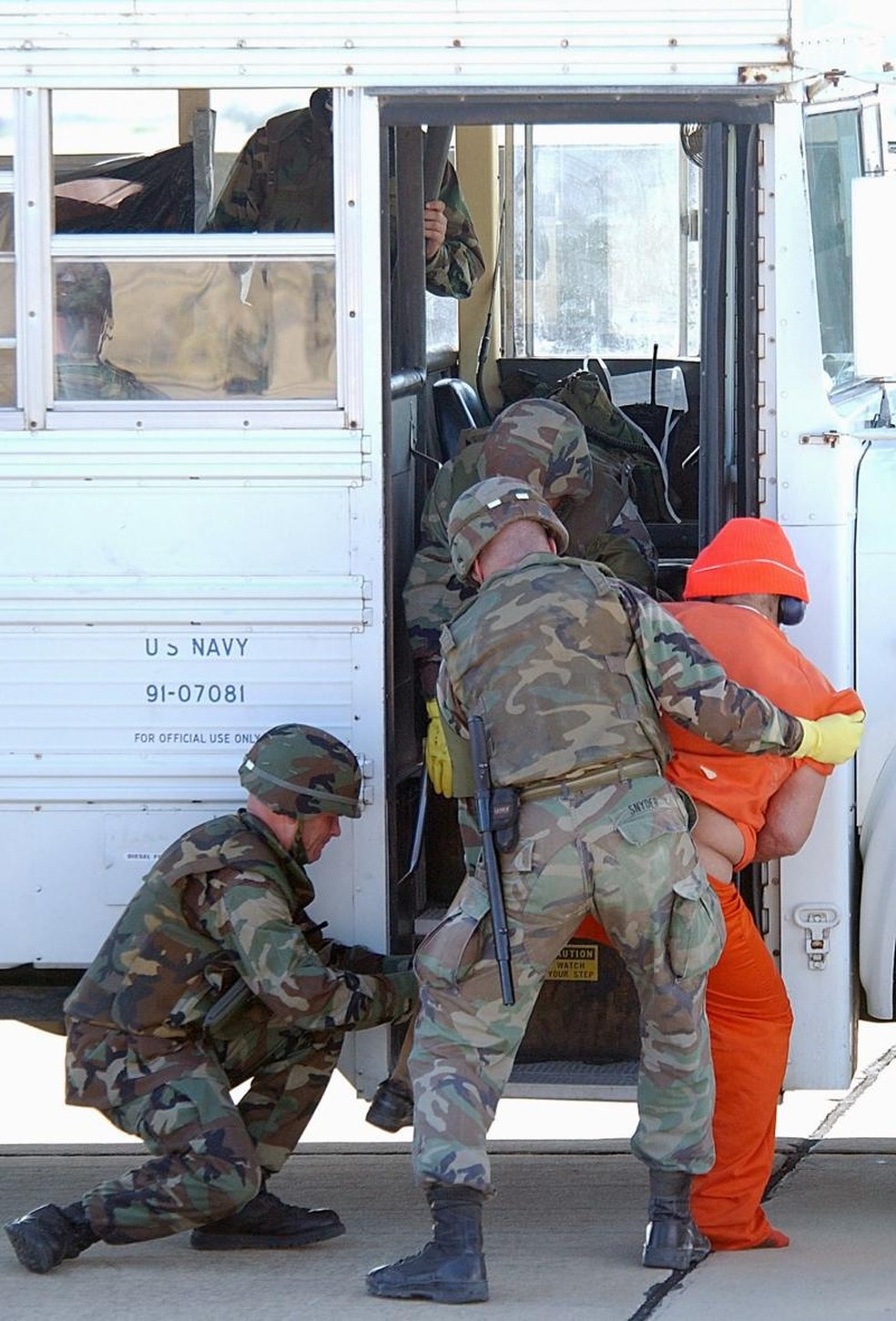 As medidas restritivas impostas aos prisioneiros complicavam a transferência, como é o caso deste detido, que possui uma prótese ortopédica. Ele foi identificado pelo jornal New York Times como Mulá Fazel Mohammad Mazloom, um líder Talibã considerado pelos EUA de alto risco. Ele passou 12 anos em Guantánamo até ser trocado, junto com outros quatro prisioneiros do Talebã, por um soldado americano. — Foto: JEREMY T. LOCK/USAF via BBC