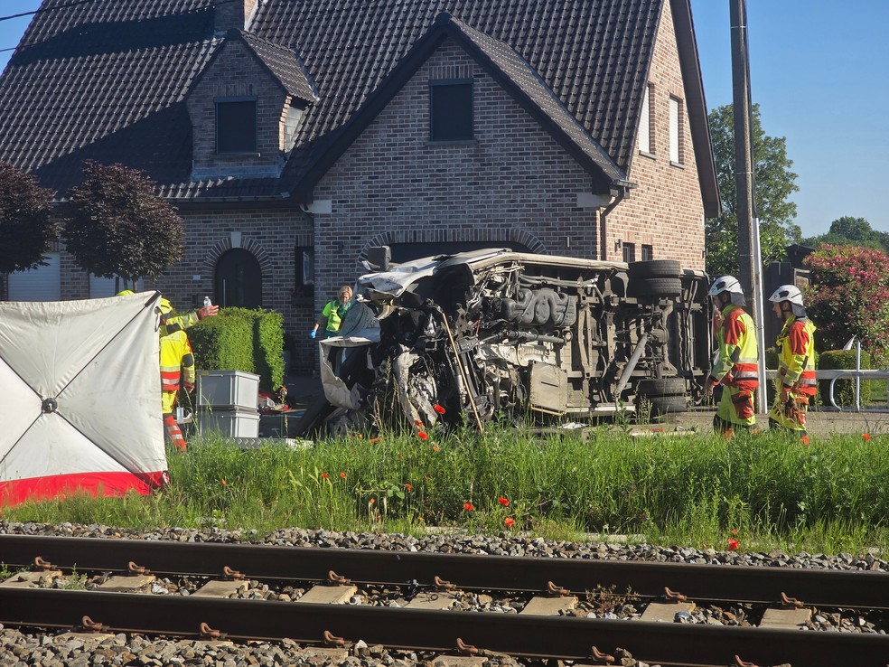 Equipes de resgate no local de uma colisão entre um trem e um veículo em Buggenhout, Bélgica — Foto: AP/Koen Baten