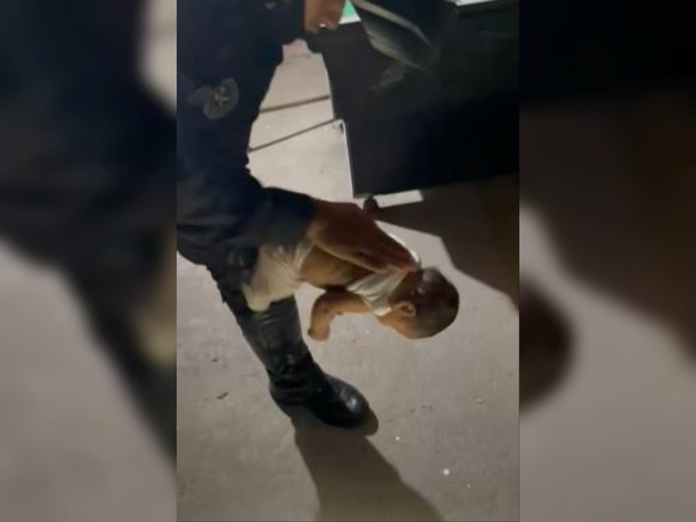 Policial pegou o bebê nos braços e aplicou a manobra de Heimlich, fazendo com que a criança voltasse a respirar. — Foto: Reprodução