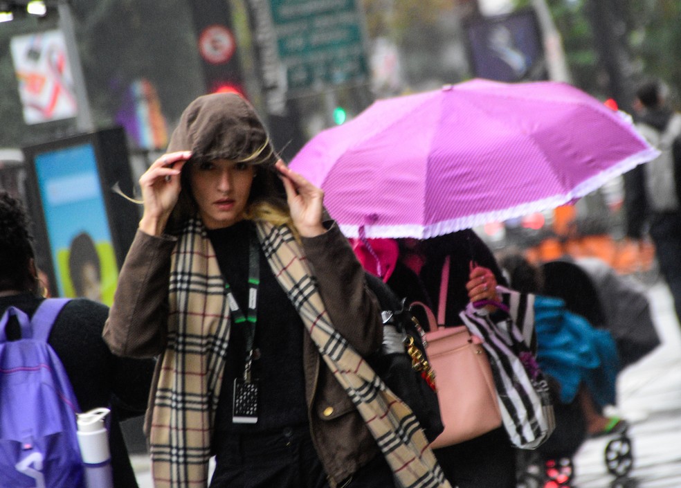 Pedestres se protegem do frio e da garoa na cidade de São Paulo, nesta manhã de segunda-feira, 13 de junho de 2023. Uma frente fria avança sobre o Brasil provocando chuva em São Paulo. A temperatura nesta terça-feira, 13, deve variar entre 15ºC a 20ºC. — Foto: RONALDO SILVA/PHOTOPRESS/ESTADÃO CONTEÚDO