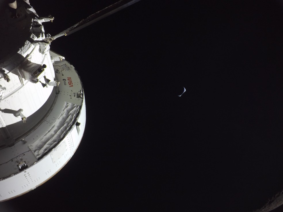 A nave Orion com a Terra em crescente ao fundo, vista durante o sobrevoo lunar da Artemis II em 6 de abril. — Foto: NASA