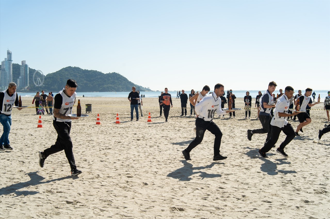 VÍDEO: corrida de garçons reúne mais de 150 profissionais em disputa na praia alargada de Balneário Camboriú