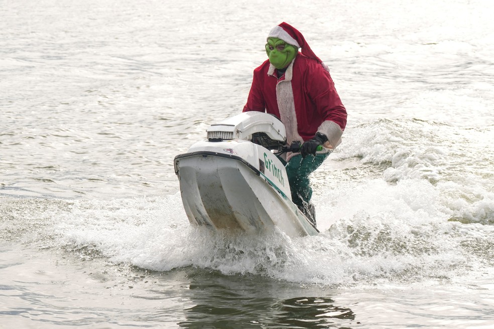 Homem vestido do personagem "Grinch", conhecido por tentar estragar o Natal, participa de evento nas águas geladas da Virginia, nos Estados Unidos — Foto: Ken Cedeno/Reuters