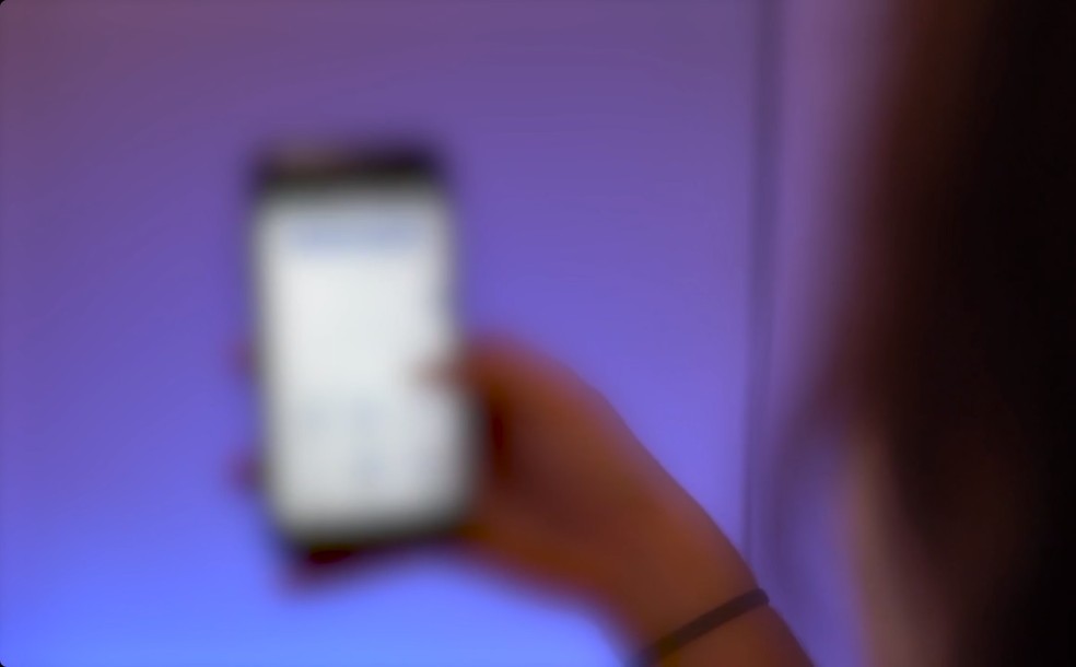 Imagem ilustrativa mostra mulher acompanhando rede social em telefone celular. — Foto: g1