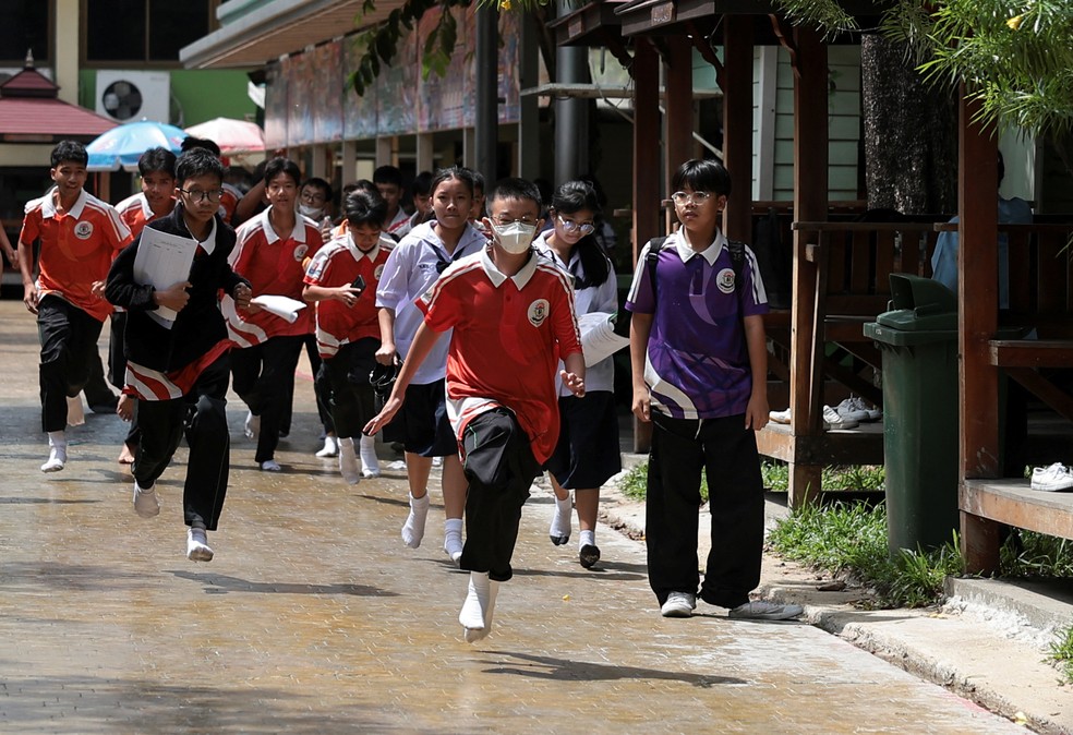 Estudantes correm enquanto evacuam a Escola Debsirin Nonthaburi, local de um tiroteio, no distrito de Bang Kruai, província de Nonthaburi, nos arredores de Bangkok, Tailândia — Foto: REUTERS