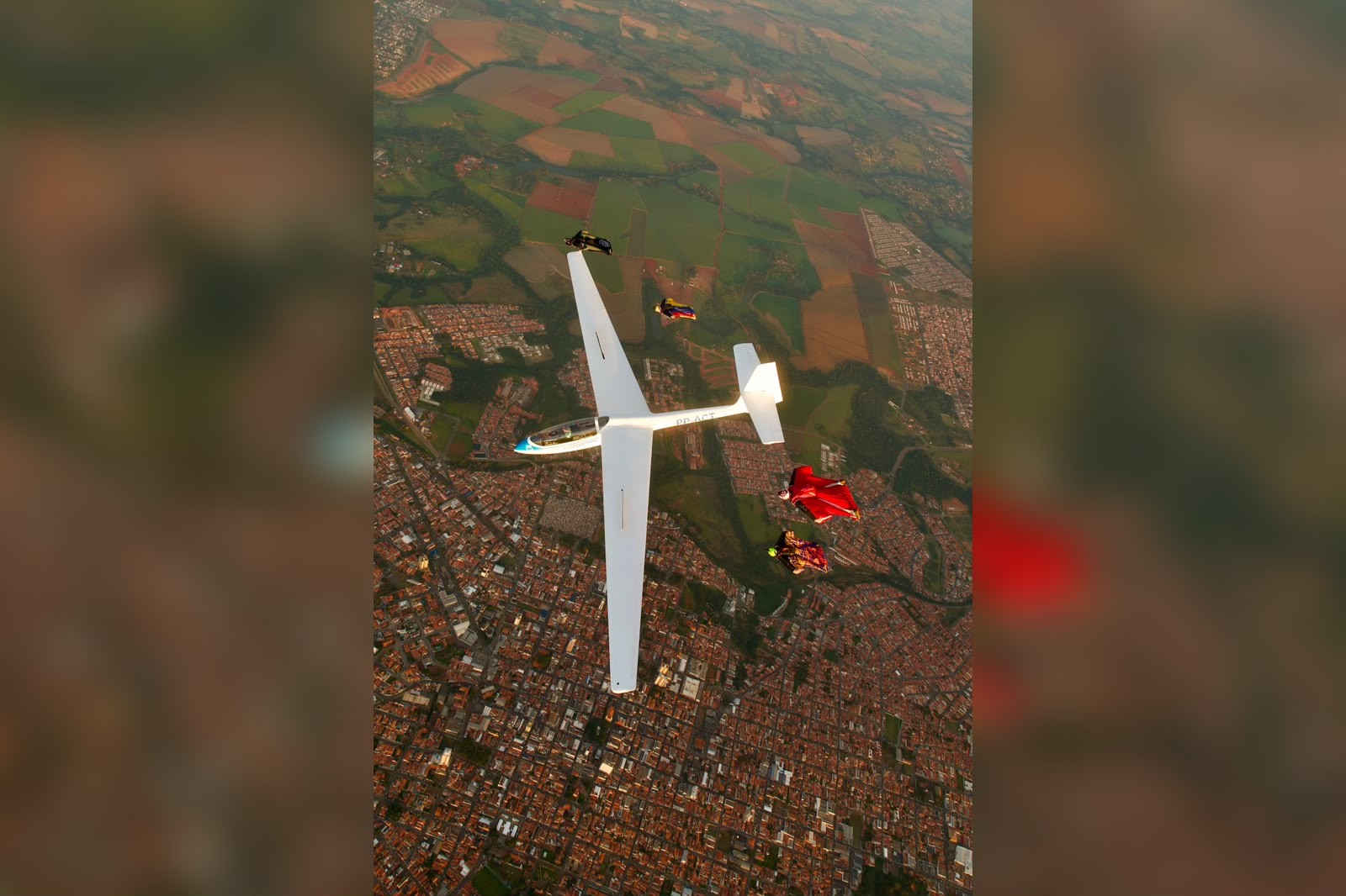 Paraquedistas voam em formação ao lado de planador e um deles chega a segurar na asa no interior de SP; vídeo