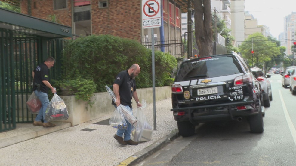 Policiais civis saem de prédio com carro material apreendido em operação contra banqueiros — Foto: Reprodução/TV Globo