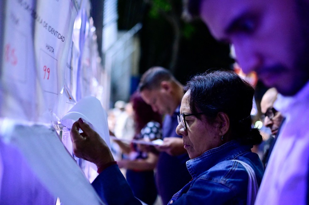 Eleitores conferem seus nomes em lista do lado de fora de seo eleitoral durante a eleio presidencial em Caracas, na Venezuela, em 28 de julho de 2024 — Foto: Reuters/Maxwell Briceno