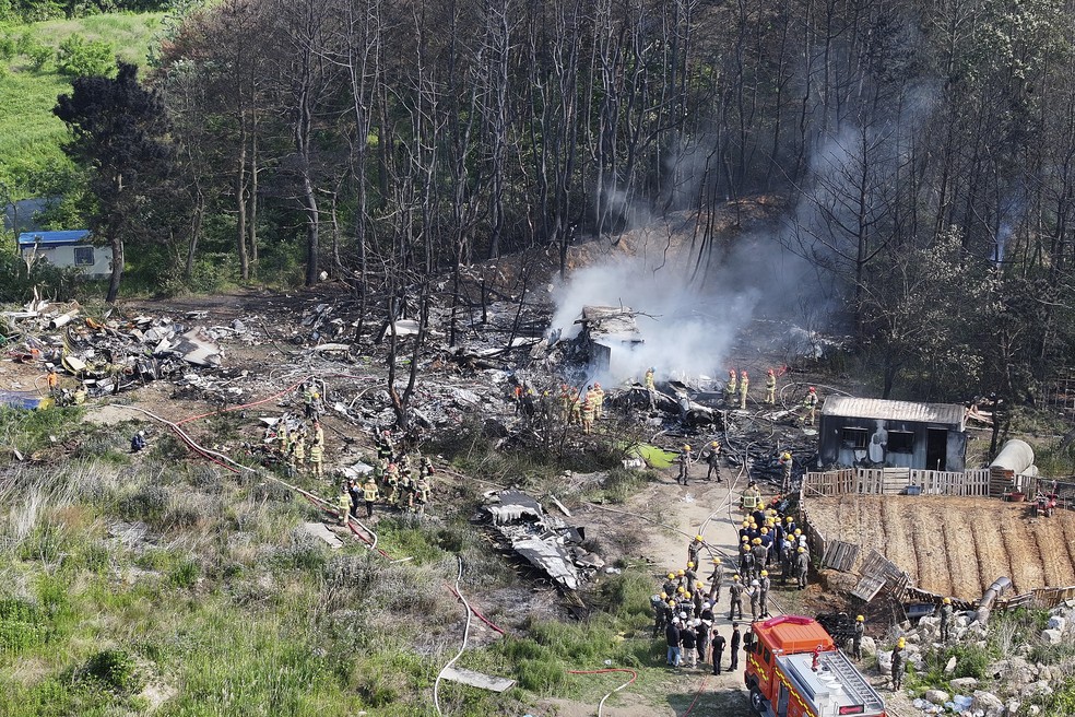 Bombeiros trabalham em local de queda de helicóptero que matou 4 em Pohang, na Coreia do Sul, em 29 de maio de 2025. — Foto: Yun Kwan-shik/Yonhap via AP