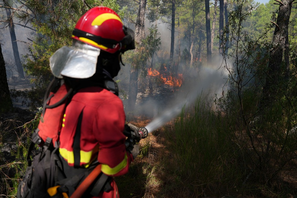 Bombeiro combate incêndio em La Atalaya, cidade residencial a 80 km da capital Madrid, no sábado (25) — Foto: Cesar Manso/AFP