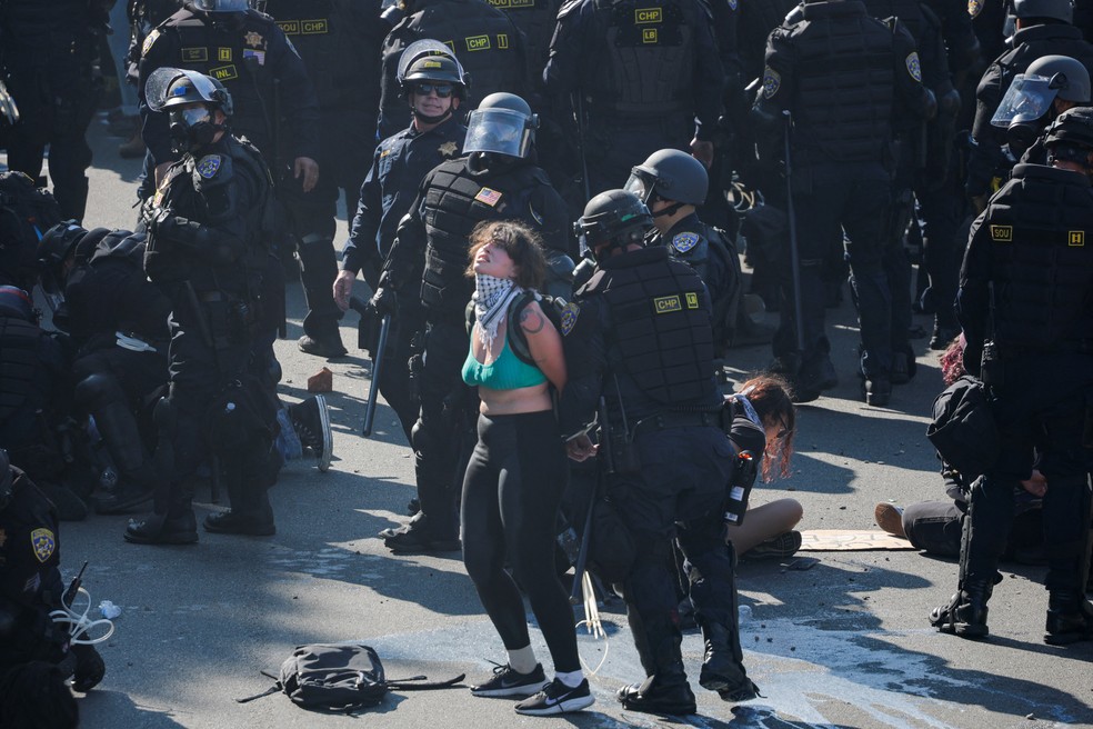 Manifestante é presa durante protestos contra as ações anti-imigração de Donald Trump — Foto: REUTERS/Mike Blake
