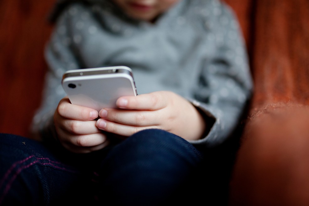 Criança no celular — Foto: Canva