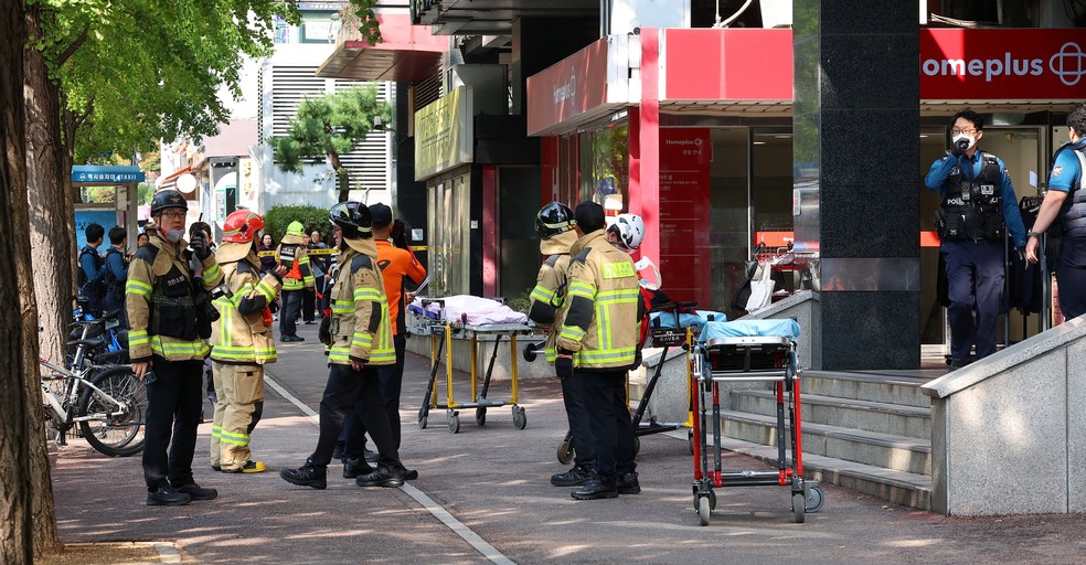 Bombeiros e policiais se reúnem do lado de fora do local onde várias pessoas ficaram feridas em um ataque a faca em Incheon, Coreia do Sul. — Foto: Yonhap via Reuters