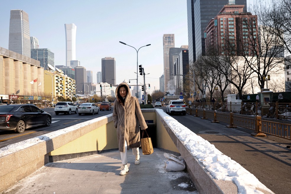 Pedestre passa por avenida do centro financeiro de Pequim em um dia frio de inverno (18/12/2023). — Foto: REUTERS/Tingshu Wang