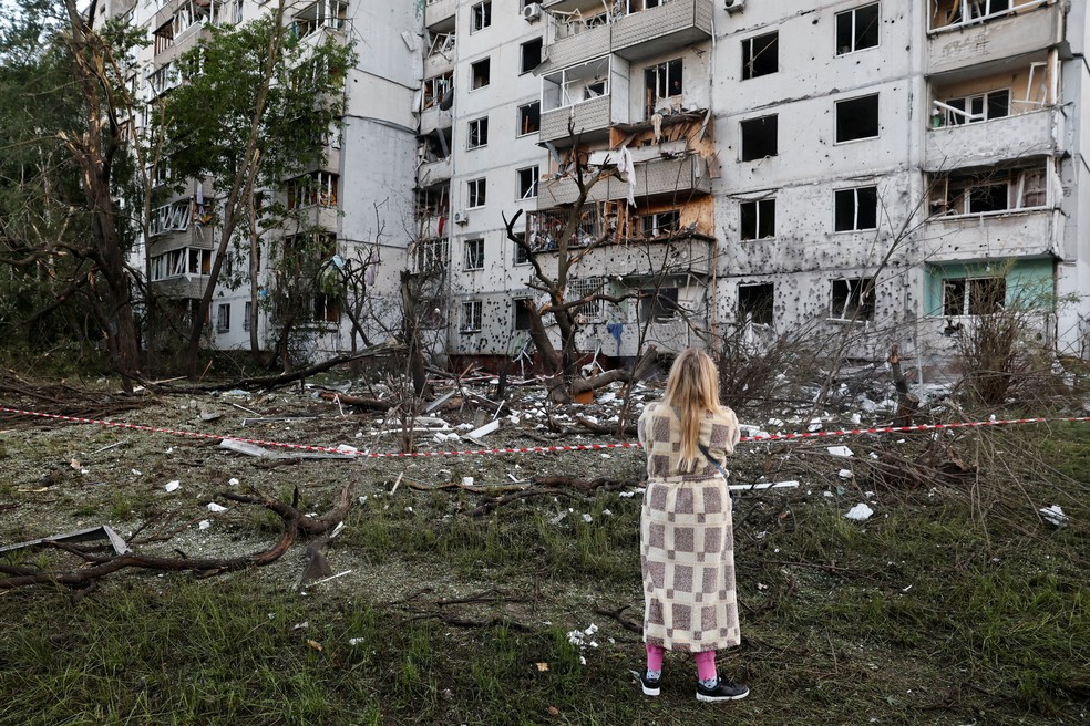 Uma mulher observa um prédio danificado durante ataques com mísseis e drones russos, em meio ao ataque da Rússia à Ucrânia, em Kiev — Foto: Thomas Peter /  Reuters