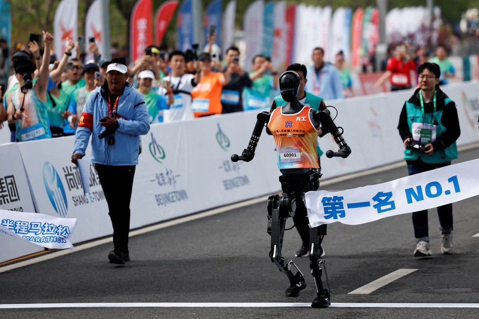 O robô humanoide Tiangong Ultra atravessa a linha de chegada de meia-maratona em Pequim, capital da China, no dia 19 de abril de 2025 — Foto: Tingshu Wang/Reyters