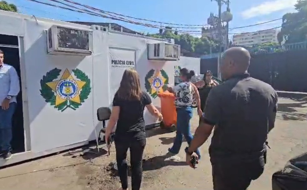 Lívia Moura sendo conduzida pela polícia — Foto: Reprodução