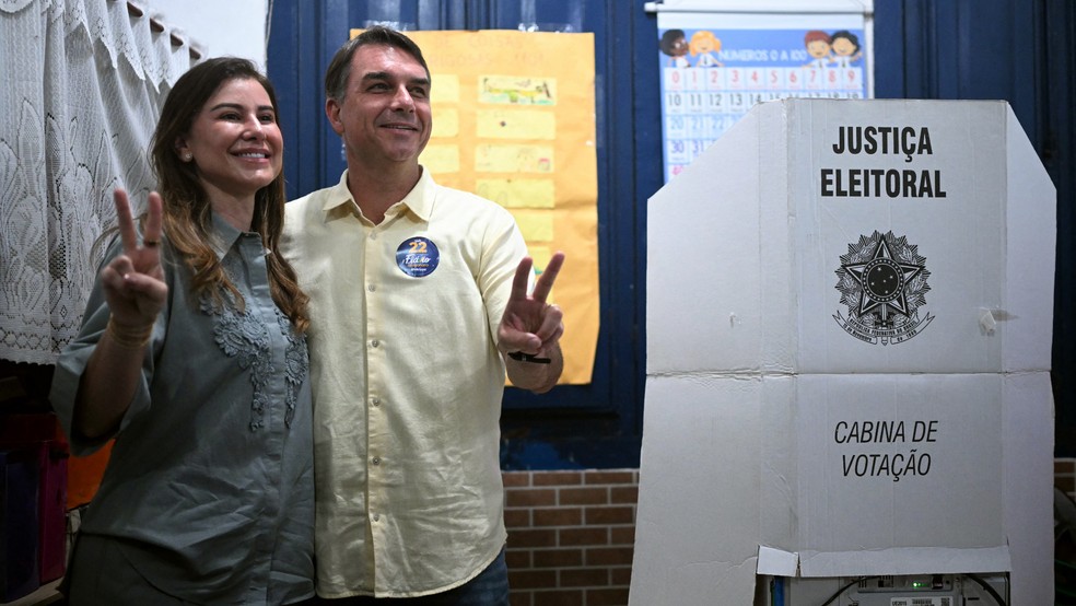 O candidato do PL à Presidência, Flávio Bolsonaro, posa para foto ao lado da esposa, Fernanda Bolsonaro, depois de votar na Escola Municipal Barão Homem de Mello, em Vila Isabel, na Zona Norte do Rio, no dia 25 de outubro de 2026 — Foto: Mauro Pimentel/AFP