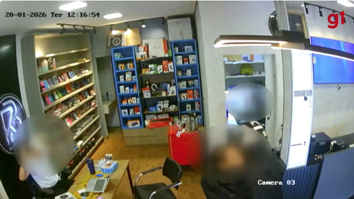 Cliente é agarrada pelo pescoço por criminoso armado durante assalto a loja de celulares; VÍDEO