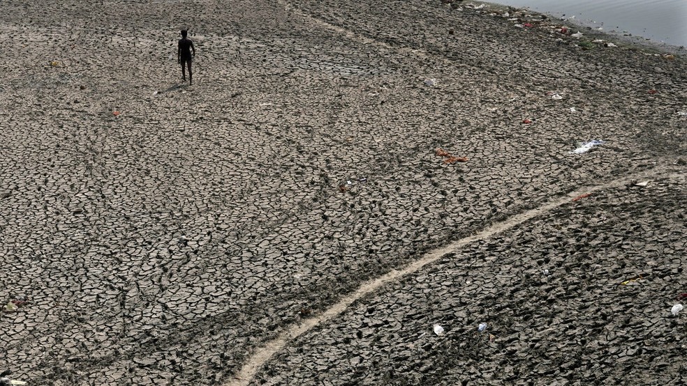 Uma pessoa caminhando no leito do rio Yamuna, cujo fluxo diminuiu drasticamente devido à onda de calor em Nova Délhi, 2 de maio de 2022 — Foto: Manish Swarup/AP