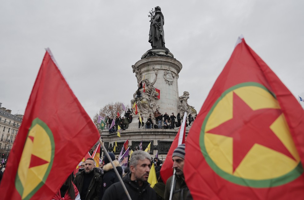 Em imagem de arquivo, ativista curdo segura bandeira do Partido dos Trabalhadores do Curdistão, o PKK, durante protestos em Paris no dia 24 de dezembro de 2022 — Foto: Lewis Joly/AP