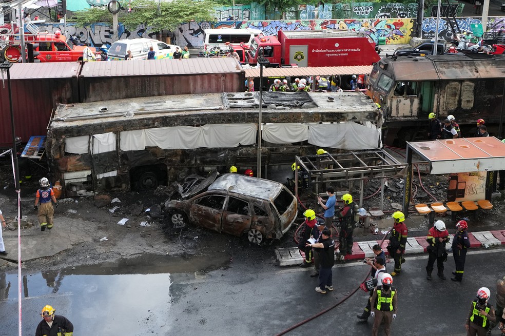 Equipes de resgate trabalham após colisão entre trem e ônibus que deixou mortos em Bangkok, capital da Tailândia, no dia 16 de maio de 2026 — Foto: Sakchai Lalit/AP