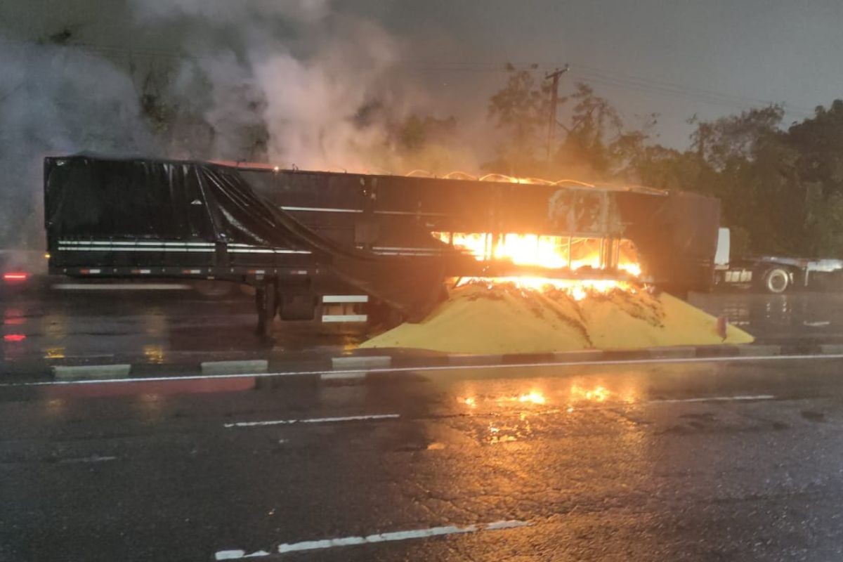 Carreta bitrem pega fogo no Porto de Santos e carga de milho fica espalhada na pista