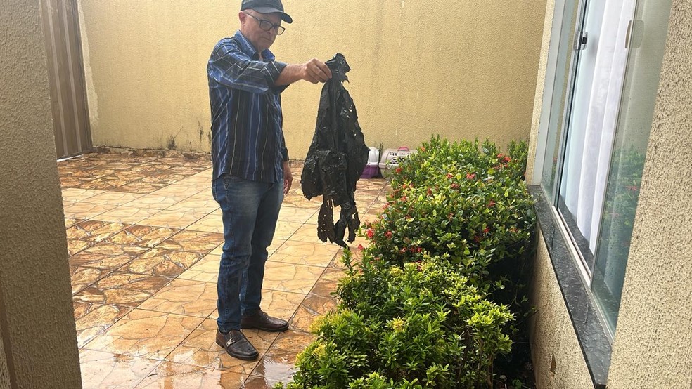 Raimundo mostra saco plástico que estava enterrado com pote de dinheiro — Foto: Ana Paula Rehbein/TV Anhanguera