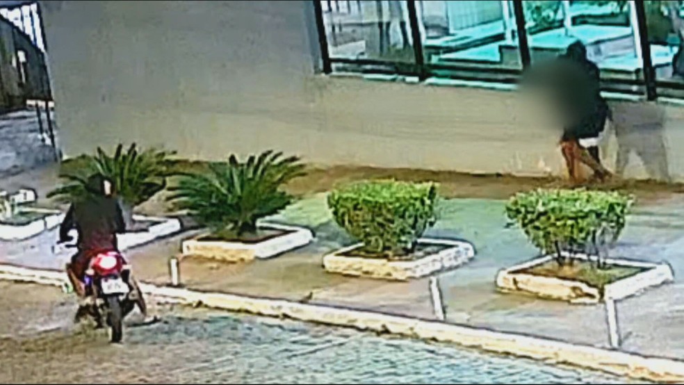 Bandido agarra mulher para levar celular na frente da Câmara de Vereadores de São João de Meriti, na Baixada Fluminense — Foto: Reprodução/ TV Globo