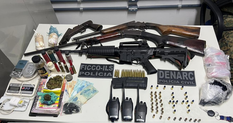 Com eles foram apreendidos um fuzil calibre 5,56, explosivos, duas espingardas um revólver, carregador, munições, rádios comunicadores, porções de drogas e uma motocicleta. — Foto: Polícia Civil da Bahia