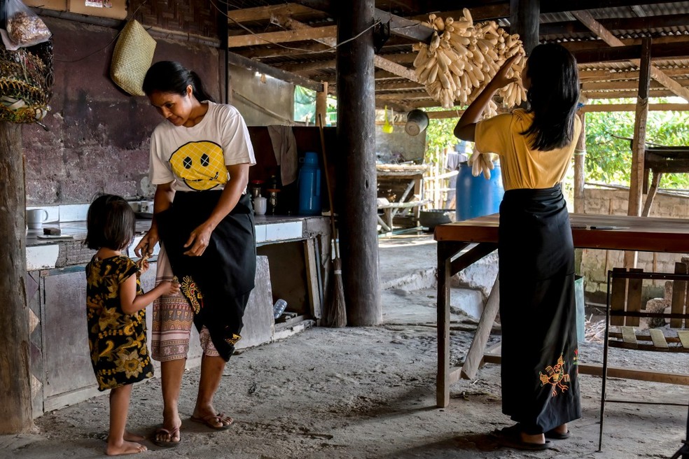 Escravizadas fazem trabalhos dom&eacute;sticos em Sumba Oriental, na Indon&eacute;sia &mdash; Foto: Bay Ismoyo/AFP
