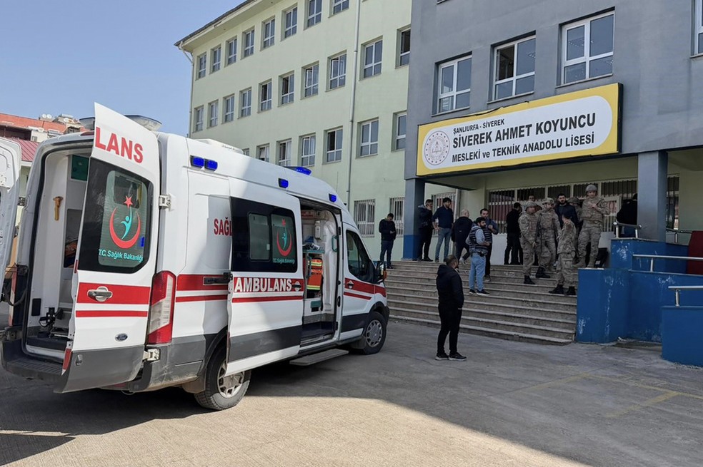 Forças de segurança turcas e equipes de emergência estão no pátio de uma escola de ensino médio onde um agressor abriu fogo, em Siverek, sudeste da Turquia, nesta terça-feira, 14 de abril de 2026. — Foto: Mevlut Bayraktar/IHA via AP