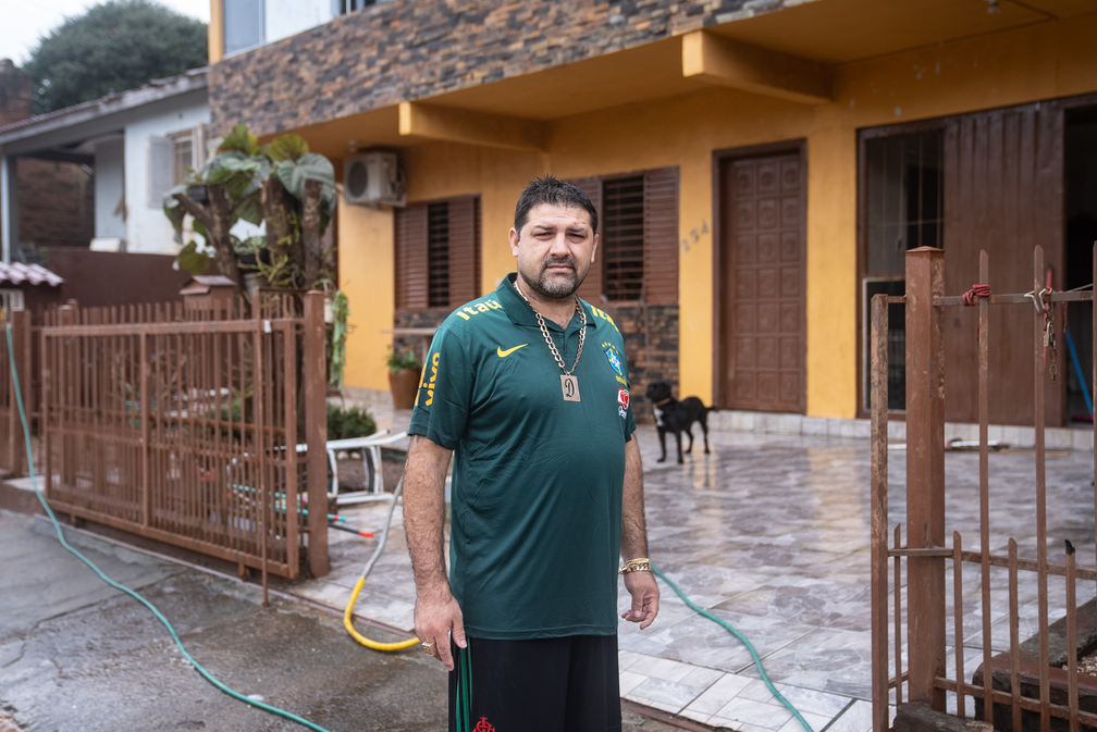 Diego Brizola faz uma pausa após limpar a lama acumulada em frente à casa de sua família no bairro de Hidráulica, em Lajeado, que foi muito atingido pela cheia do Rio Taquari — Foto: Fábio Tito/g1