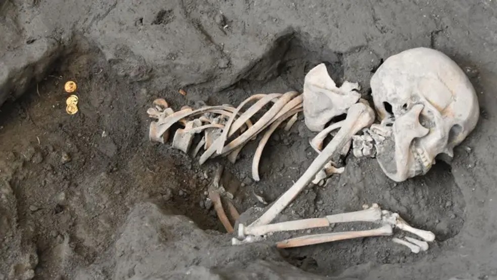 O esqueleto de uma mulher, segurando moedas, foi encontrado curvado em posição fetal. — Foto: ARCHAEOLOGICAL PARK OF POMPEII/SOPHIE HAY
