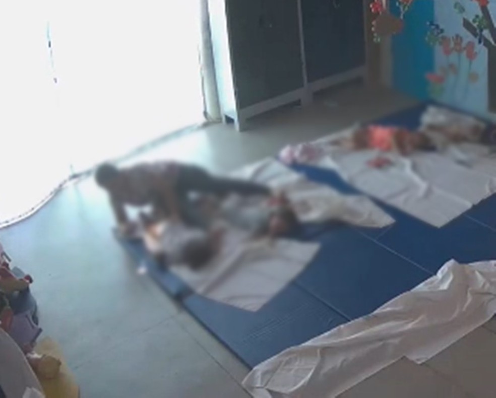 Funcionária tirando foto de criança de bruços e utilizando fralda — Foto: Reprodução/TV Cabo Branco