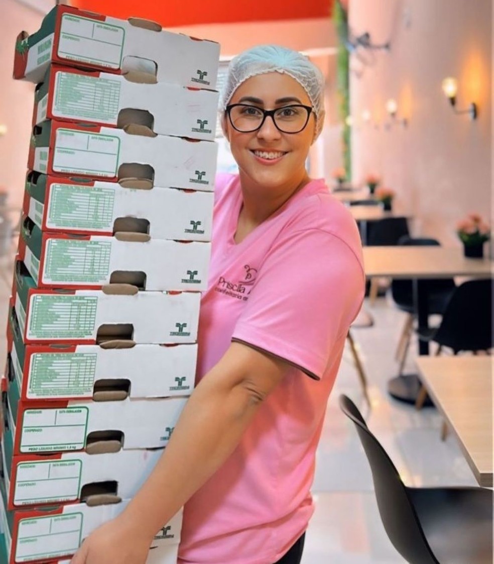 Priscila Alves segura caixas de morango que chegam diariamente para dar conta da alta produção — Foto: Priscila Alves/Divulgação