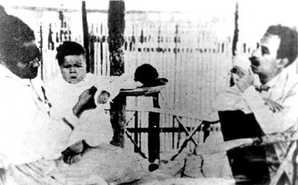 Carlos Chagas e a bebê Rita, uma das pacientes atendidas por ele — Foto: Prefeitura de Lassance/Divulgação