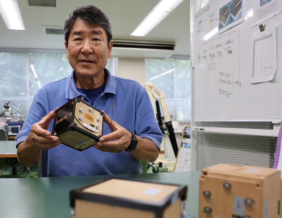 Takao Doi, ex-astronauta japonês e professor da Universidade de Kyoto com o satélite LignoSat, em foto de 25 de outubro de 2024 — Foto: Reuters/Irene Wang